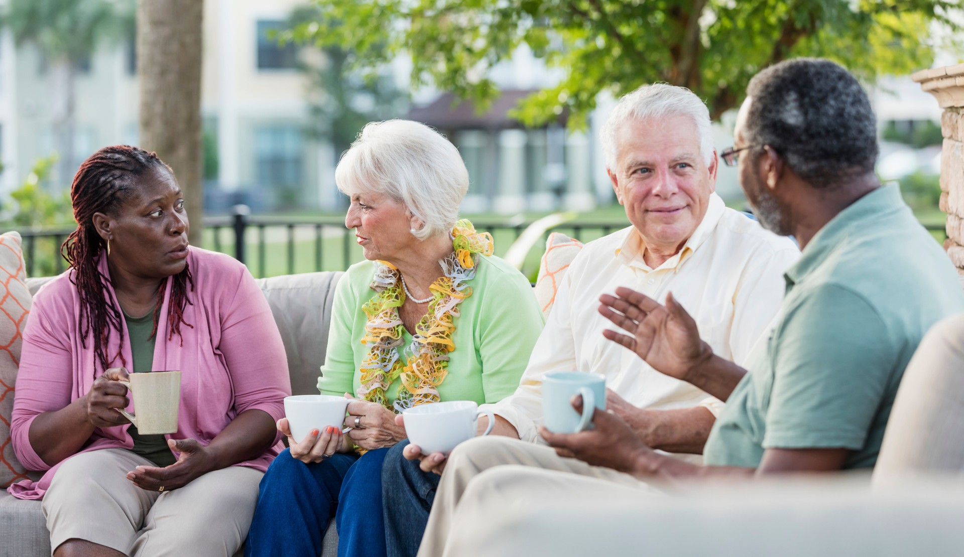 Two older couples hanging out on patio, conversing